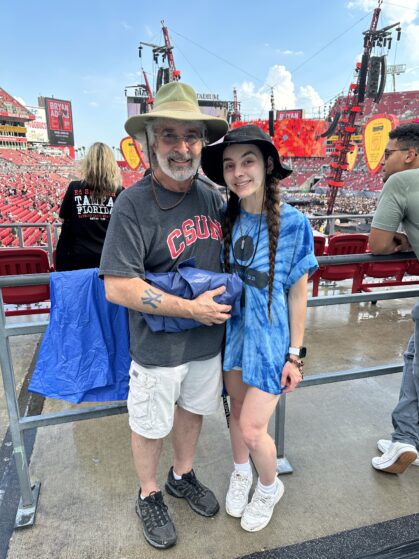 Lisa and her dad wearing bucket hats in front of Ed Sheeran's stage.