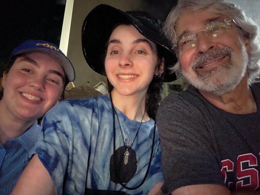 Anna, Lisa and their dad smiling at the camera while watching the Ed Sheeran concert.