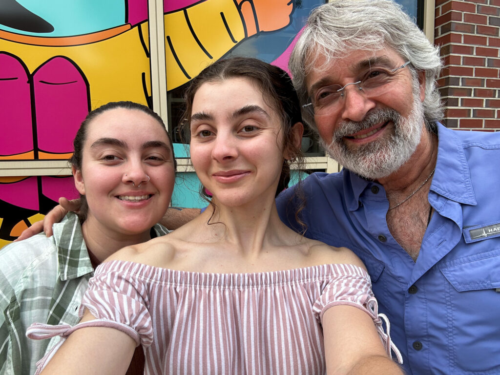 Two sisters and their dad in front of the Florida State University Student Life Cinema.