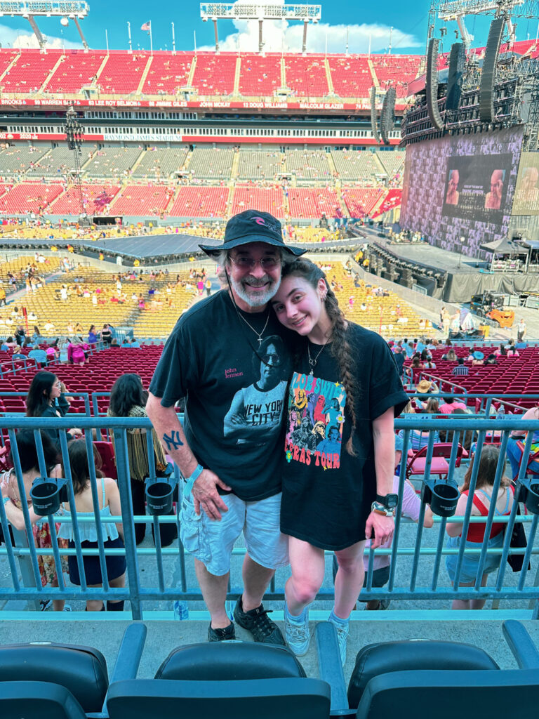 Lisa and her dad in front of a railing before the inside Raymond James Stadium.