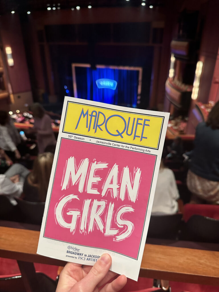 Mean Girls the Musical pink and white program.