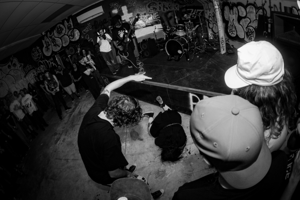 black and white photo of teenager on the floor at a concert