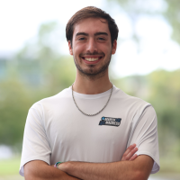 Ryan in a white t-shirt standing outside